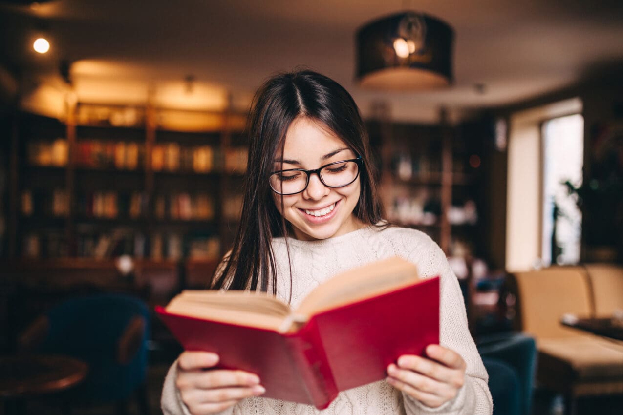 Young beautiful student girl reading a book